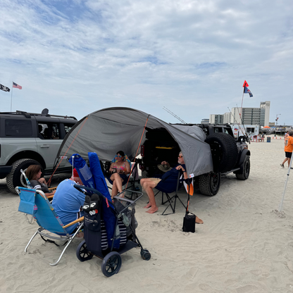 Trail Gear Oasis 2-in-1 Trail Cover & Sun Shade set up on a Bronco providing shade at the beach.
