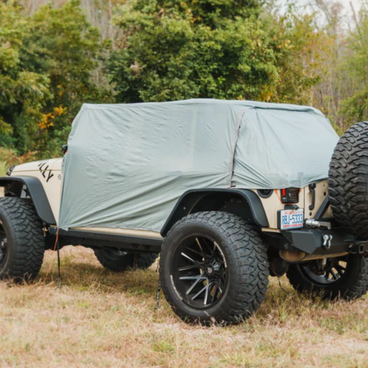 Trail Gear Oasis 2 in 1 Jeep Trail Cover and Sun Shade covering a Jeep Wrangler from rear side angle