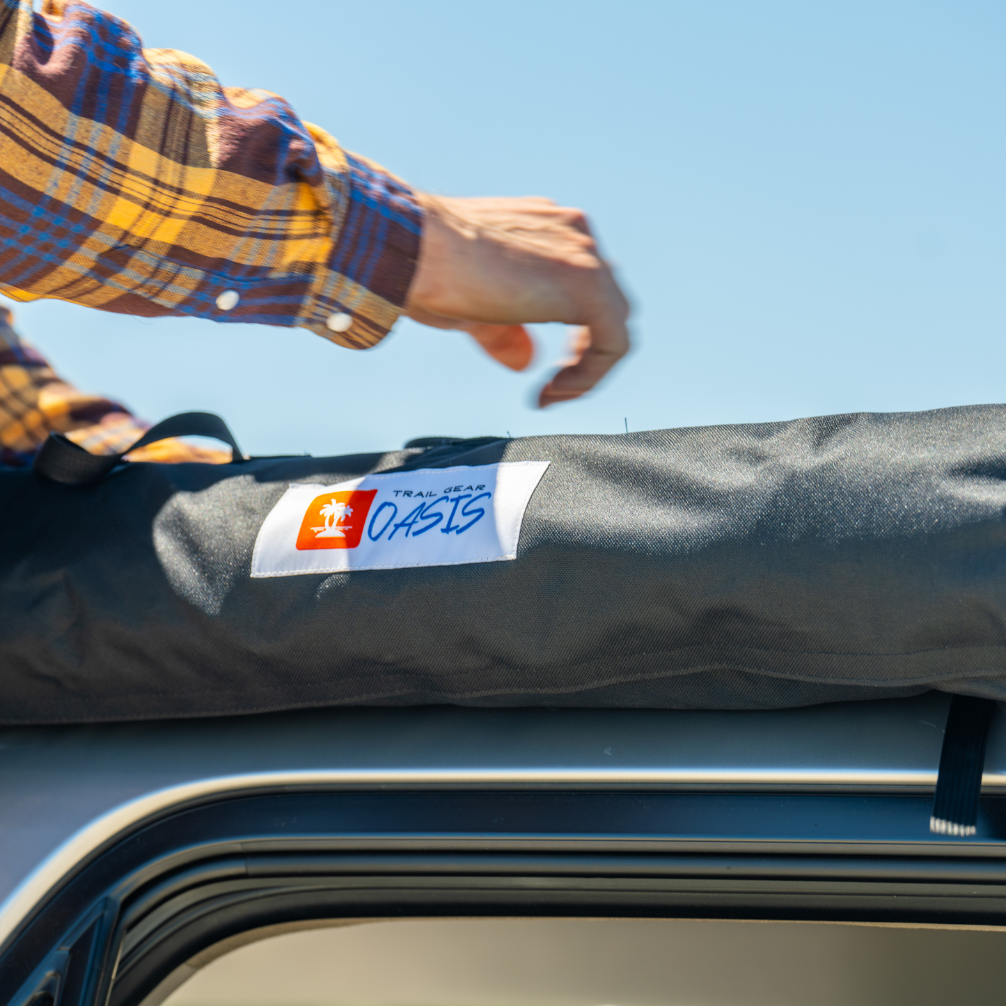 Trail Gear Oasis SUV trail cover packed in storage bag on roof rack at beach location