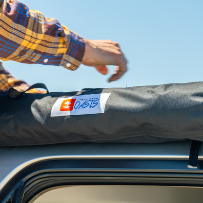Trail Gear Oasis SUV trail cover packed in storage bag on roof rack at beach location