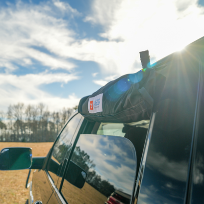 Trail Gear Oasis branded storage bag mounted on truck door in outdoor setting