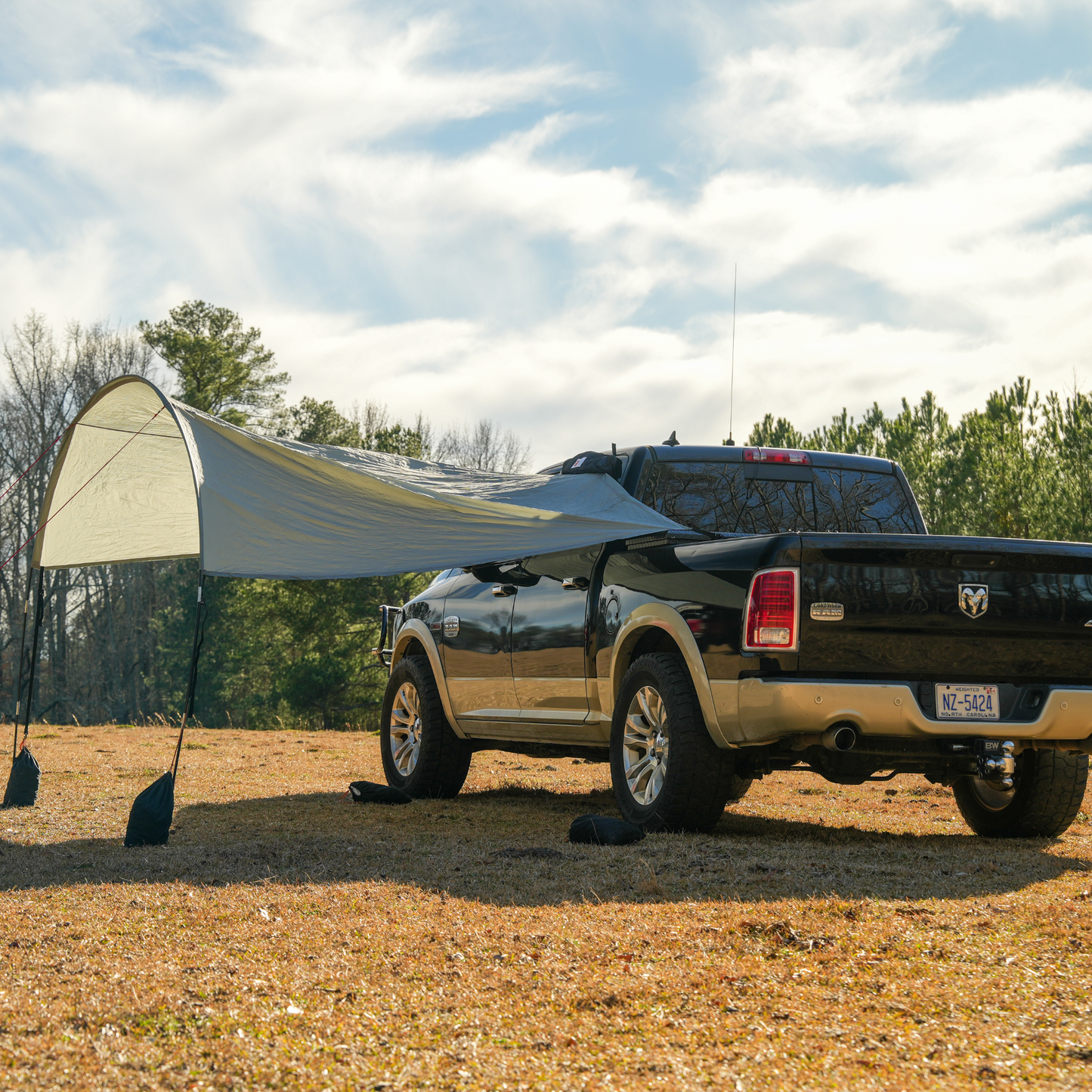 Trail Gear Oasis truck trail cover fully deployed on Ram pickup in open field showing complete shade setup