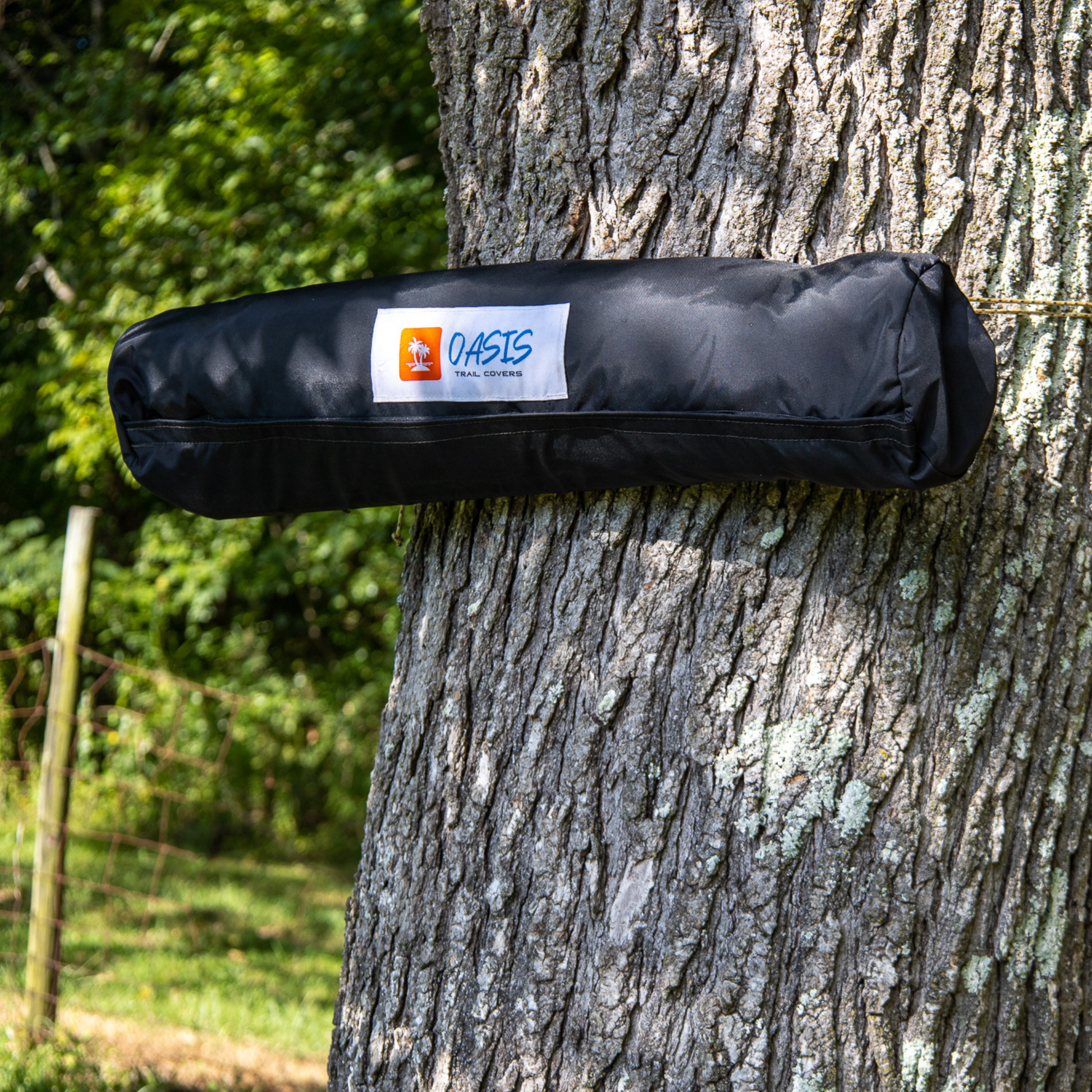 Trail Gear Oasis branded storage bag strapped to tree trunk showing portable mounting system for Sidekick Shade